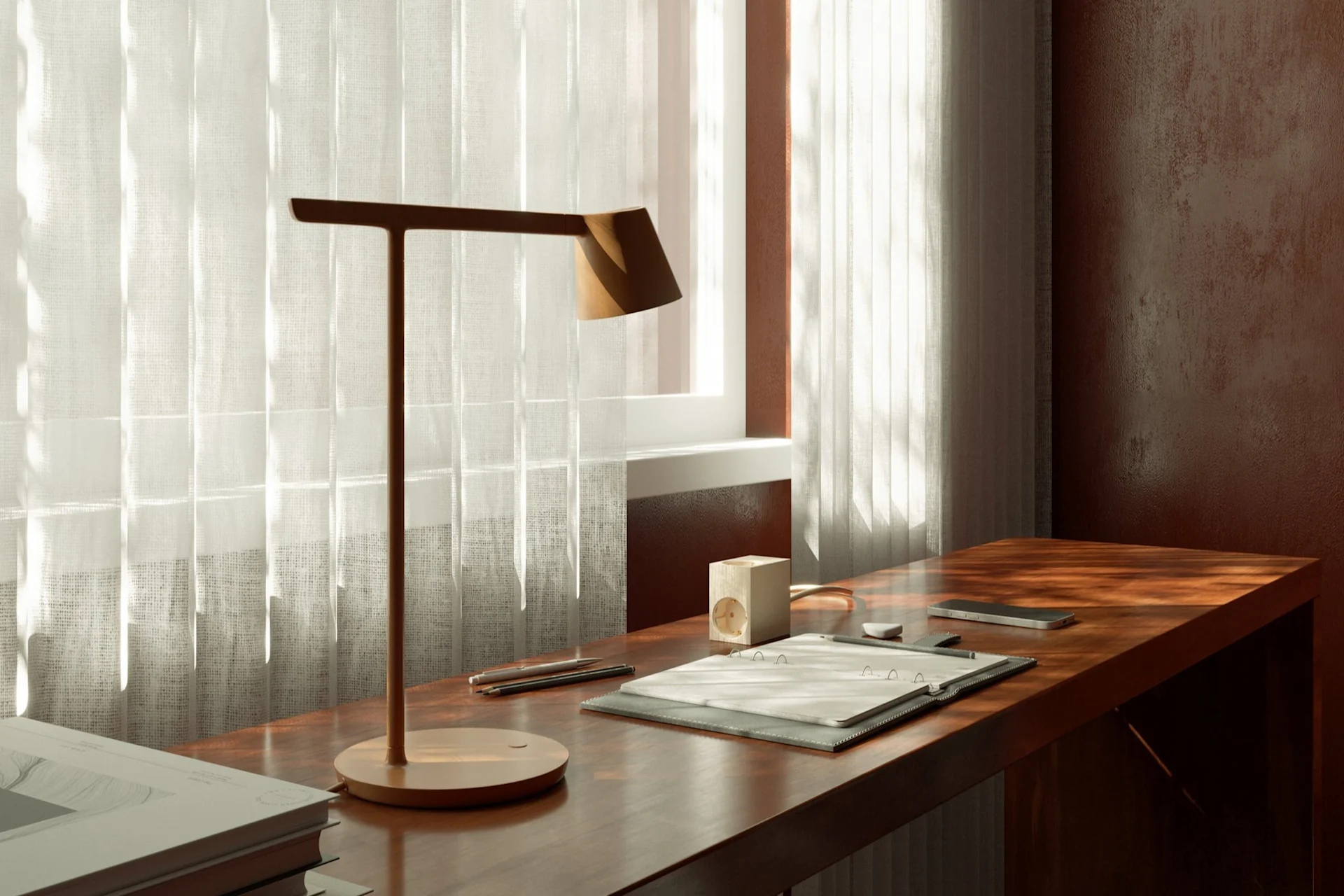 Een werkplek met een moderne bureaulamp, notitieblok en smartphone op een houten bureau bij een raam met vitrage.