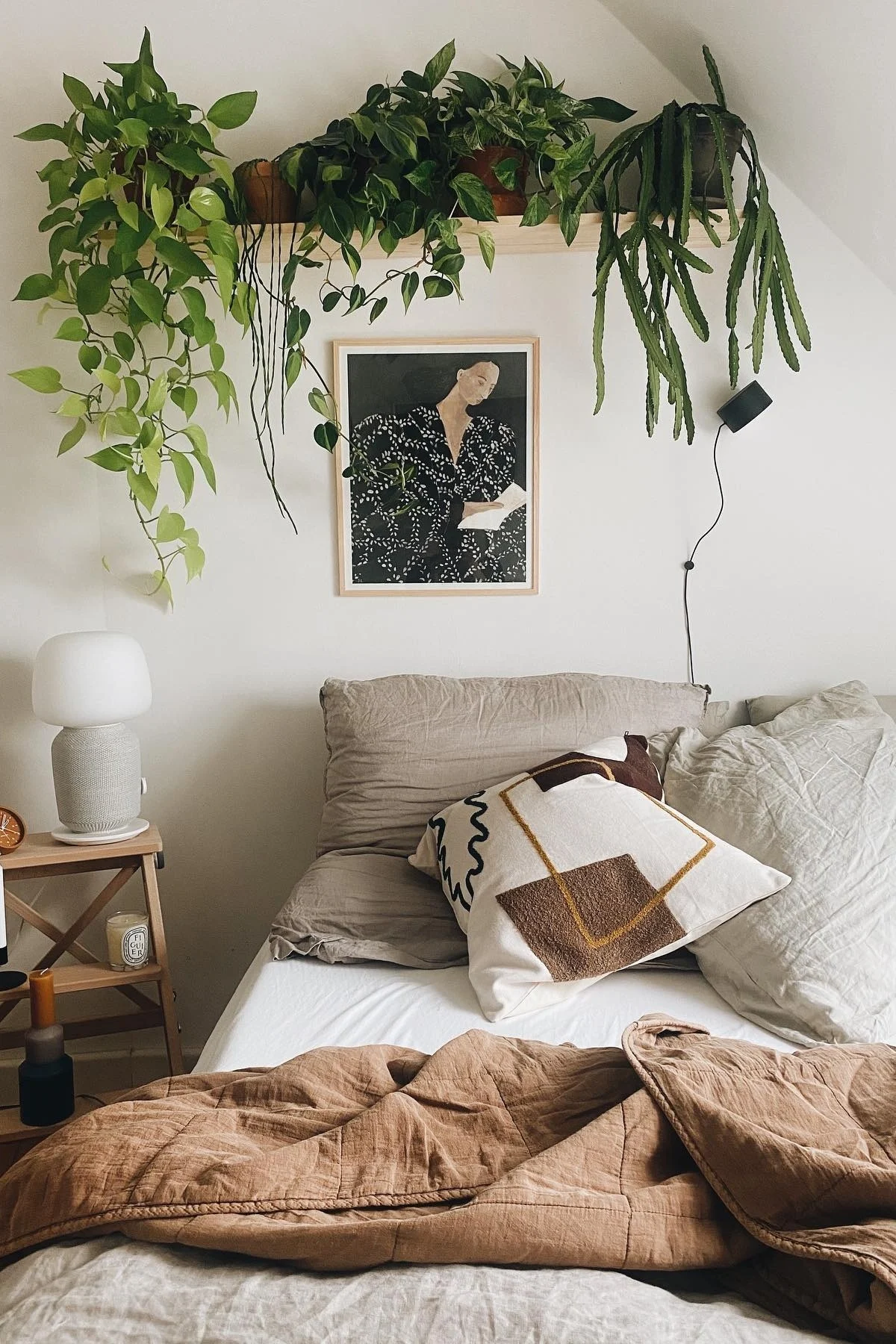 Boho en andere inrichtingsstijlen: creëer een gezellige slaapkamer zoals die van Instagram-gebruiker @unterm.dach met planten en verschillende tinten bruin en beige.