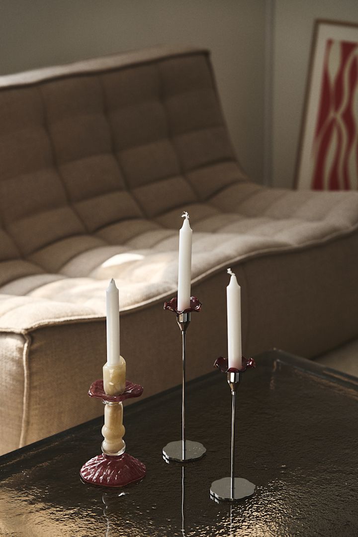 De Lara-kandelaar van Byon, staat op een salontafel met glazen blad, deze is vervaardigd uit gekleurd glas in beige en wijnrood. Het ontwerp is geïnspireerd op Romeinse zuilen.