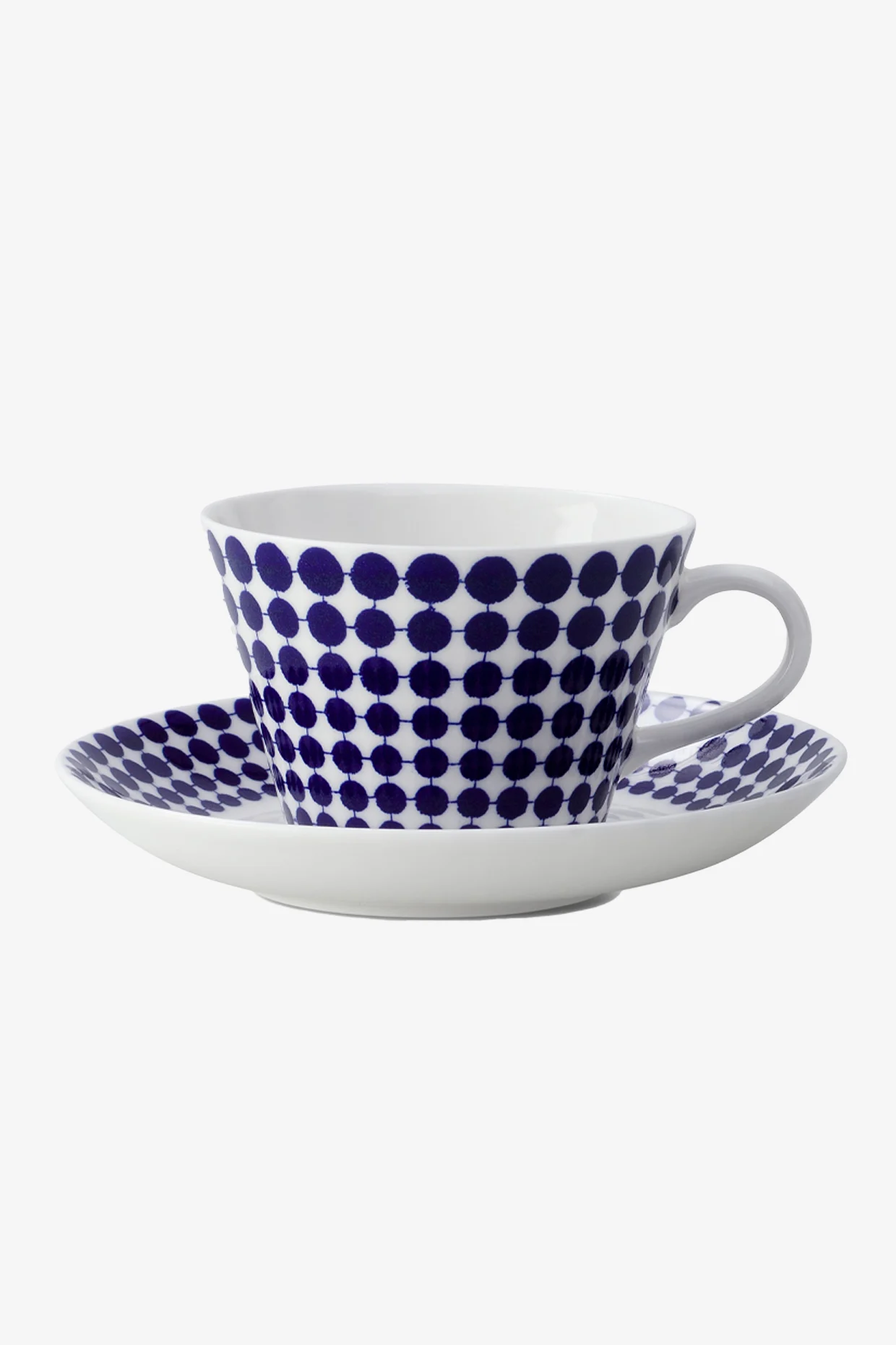Witte theekop en schotel met een blauw polkadotpatroon.