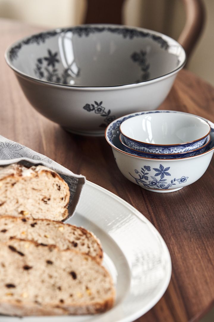 Ostindia grote kom in het zwart en kleine kommen in het blauw, op een rustieke tafel.
