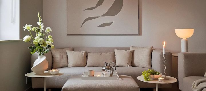Creëer een gezellige hygge woonkamer met kaarsen, neutrale kleuren en natuurlijke materialen. 