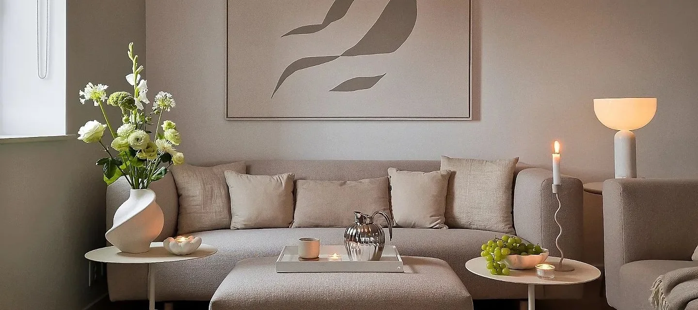 Creëer een gezellige hygge woonkamer met kaarsen, neutrale kleuren en natuurlijke materialen.