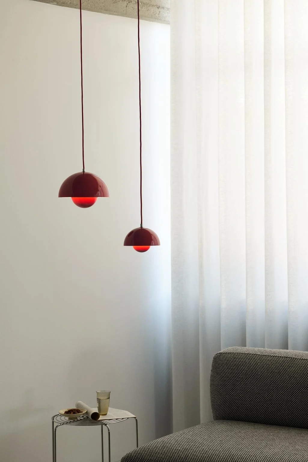 Verlevendig je huis met deze moderne ideeën voor plafondverlichting. Hier zie je de Flowerpot lamp van &Tradition in twee verschillende maten hangen in een woonkamer boven een bank. 