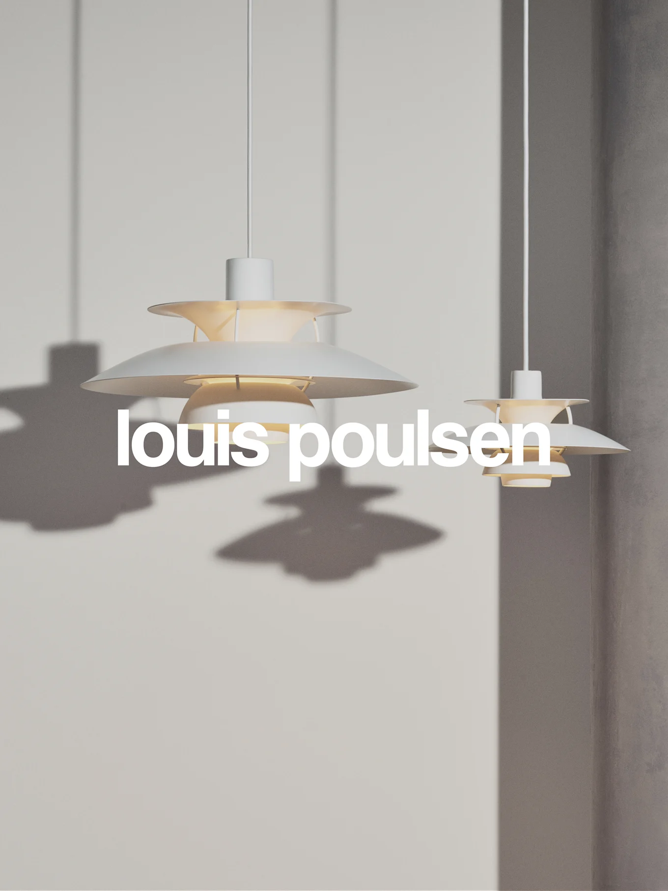Twee witte, gelaagde hanglampen hangen tegen een lichtgrijze muur, met de tekst 'louis poulsen'.