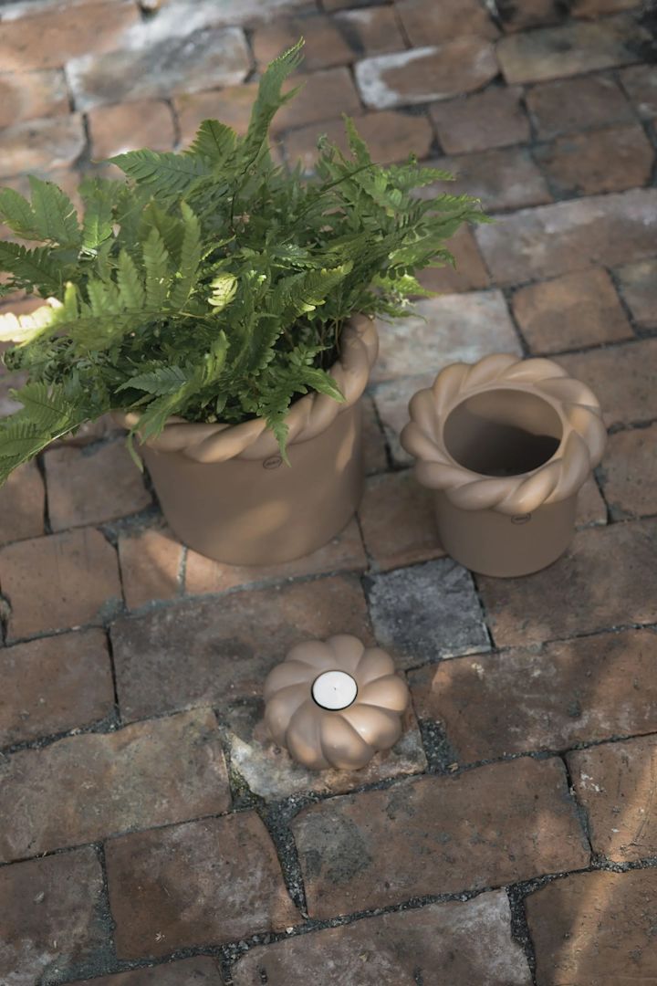 Bloempotten voor buiten: Hier zie je de Twine bloempot in beige in verschillende maten op een terras staan.