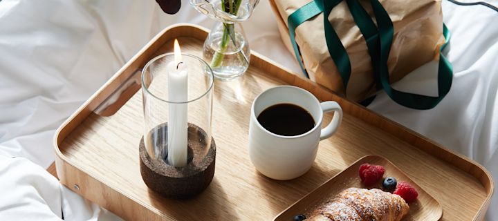 Vier Valentijnsdag thuis met een romantisch diner voor twee, ontbijt op bed of zelfgemaakte koffie. Hier is een tafelschikking met linnen tafelkleed en mooie glazen, servetvouwen en vaas voor het Valentijnsboeket.
