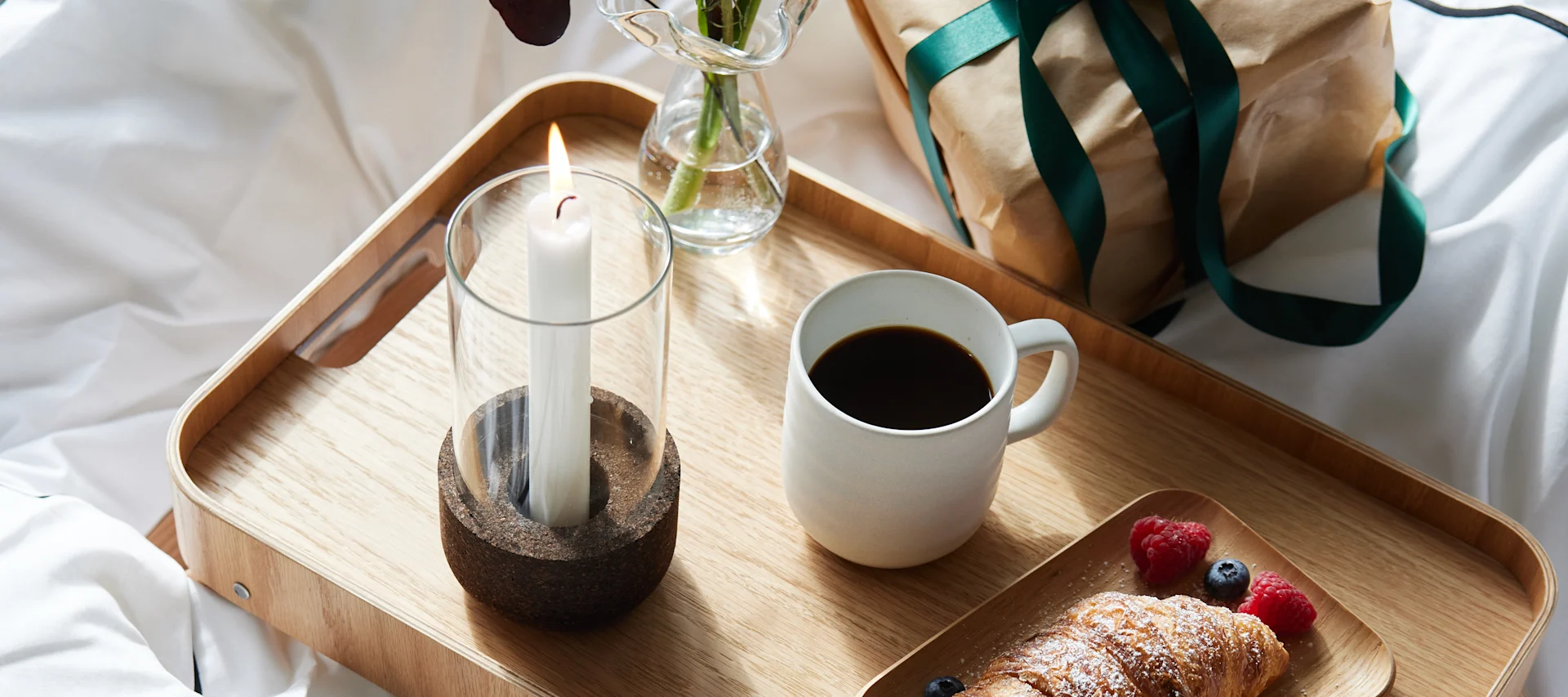 Vier Valentijnsdag thuis met een romantisch diner voor twee, ontbijt op bed of zelfgemaakte koffie. Hier is een tafelschikking met linnen tafelkleed en mooie glazen, servetvouwen en vaas voor het Valentijnsboeket.