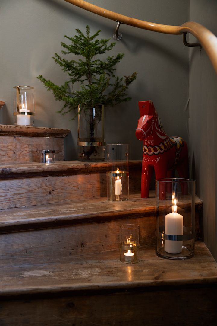Breng de kerstsfeer naar de trap: decoreer de treden met de Hold-vazen van Sagaform in verschillende maten, gevuld met kaarsen en takjes sparrengroen. Maak het geheel af met een decoratieve Dala-tak voor een sfeervol accent.