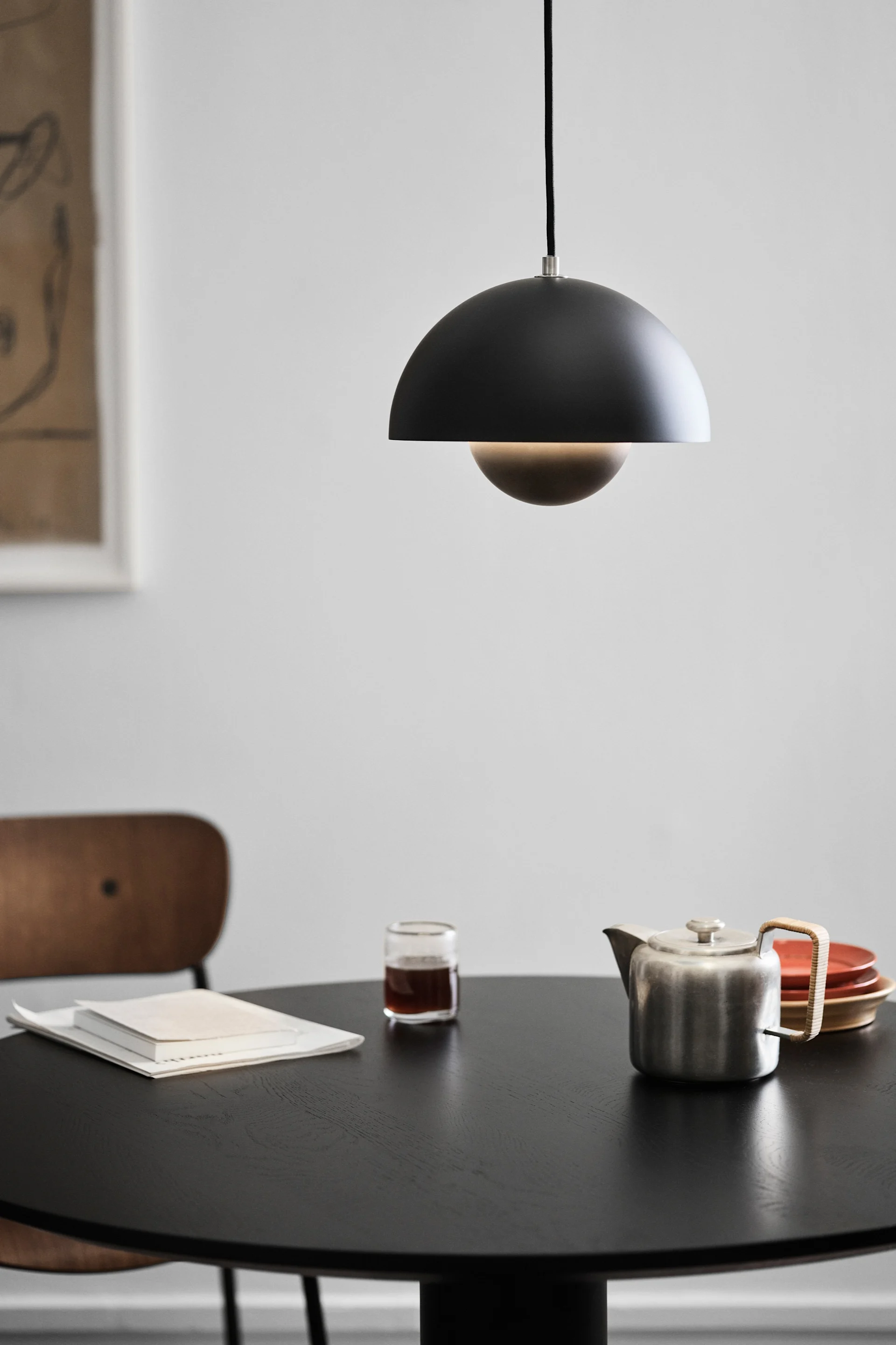 Hier zie je een Scandinavische designlamp, de Flowerpot VP1 van &Tradition, in een raam hangen.