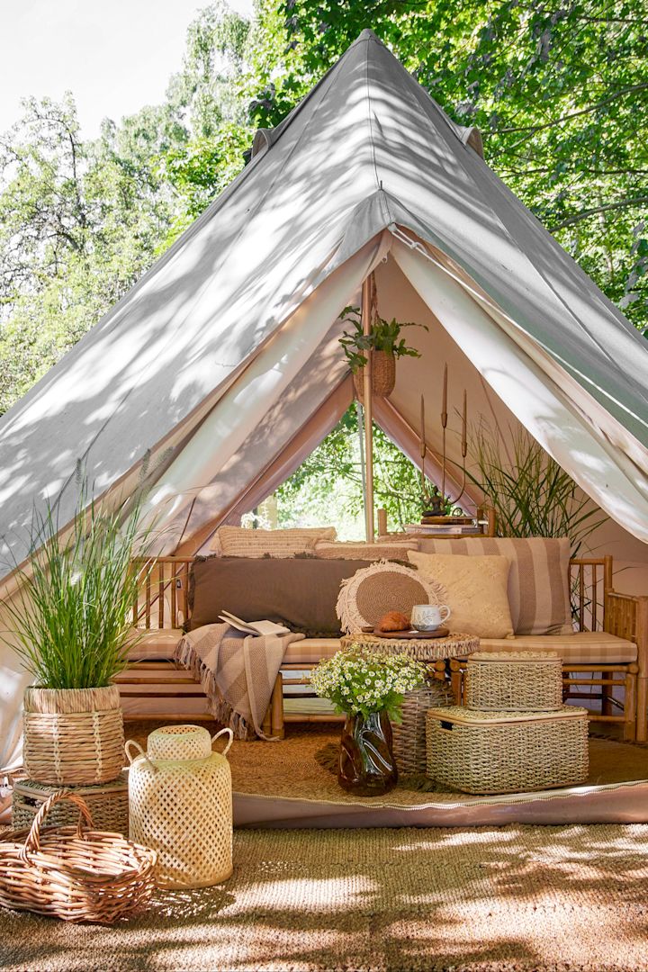 Verdubbel de gezelligheidsfactor van je terras met buitenlantaarns en windlichten door het in een boho stijl te decoreren en bijvoorbeeld de Musu jute lantaarn van Bloomingville op te hangen.