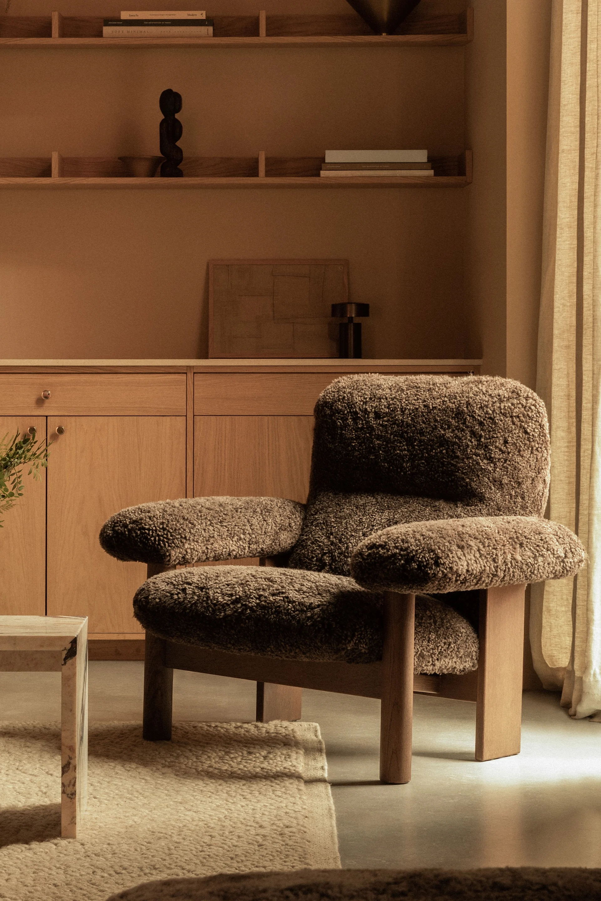 Robuust meubilair is een belangrijk onderdeel van de Scandinavische meubeltrends 2025 - hier de Brasilia fauteuil van Audo Copenhagen in bruine schapenvacht.