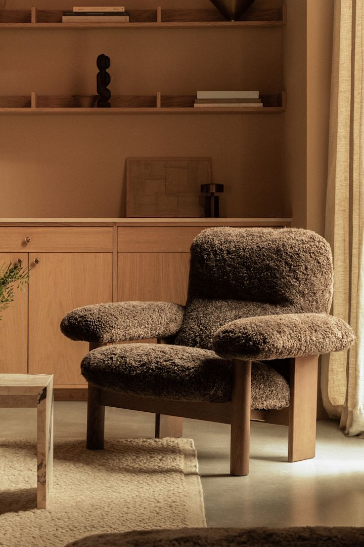 Robuust meubilair is een belangrijk onderdeel van de Scandinavische meubeltrends 2025 - hier de Brasilia fauteuil van Audo Copenhagen in bruine schapenvacht.