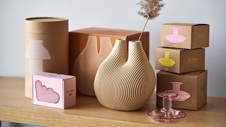 De W&S kamervaas in beige van HAY omringd door de kleurrijke productdozen.