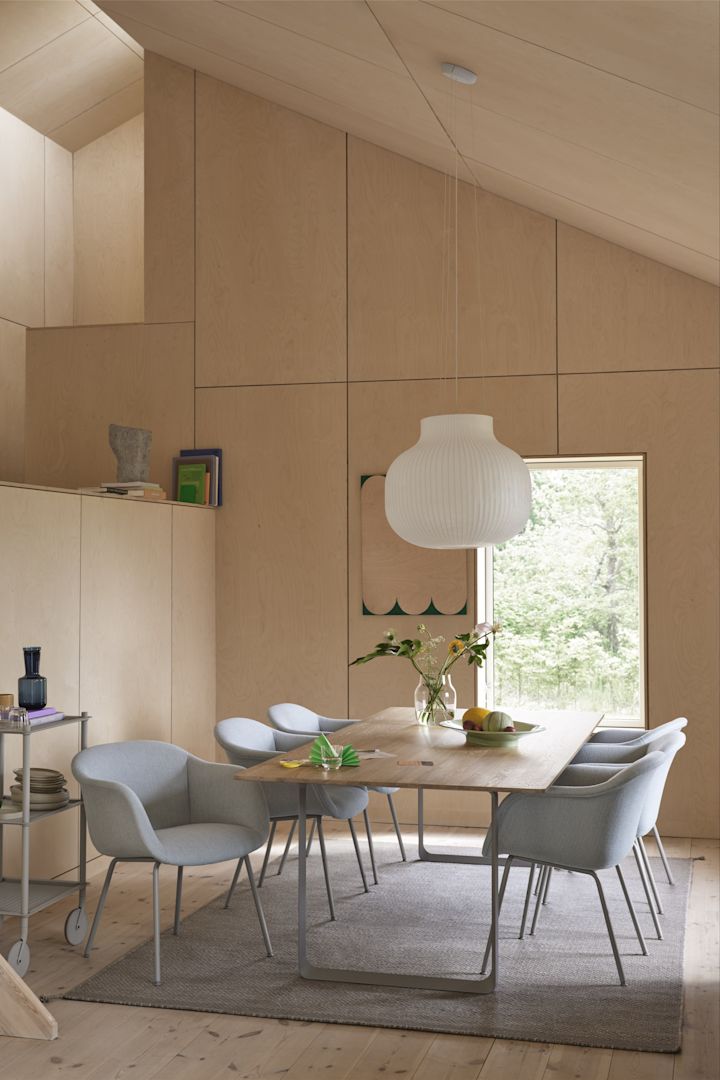 Vloerkleden voor de eethoek: Het grijze Ply wollen vloerkleed van Muuto ligt in een eetkamer in Scandinavische stijl met lichtblauwe stoelen en veel hout.