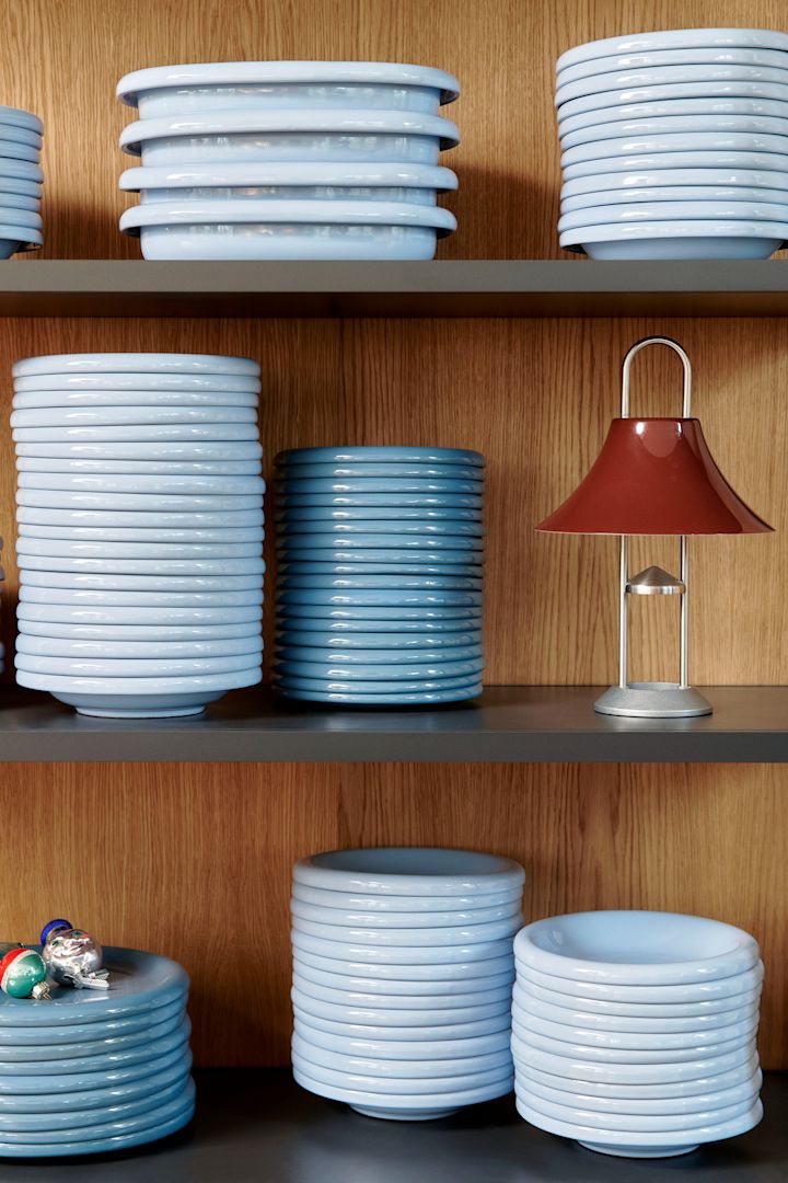 Hemelsblauw is een belangrijke kleur onder de interieurtrends van 2025. Hier zie je een stapel Barro borden van Hay op een houten plank.