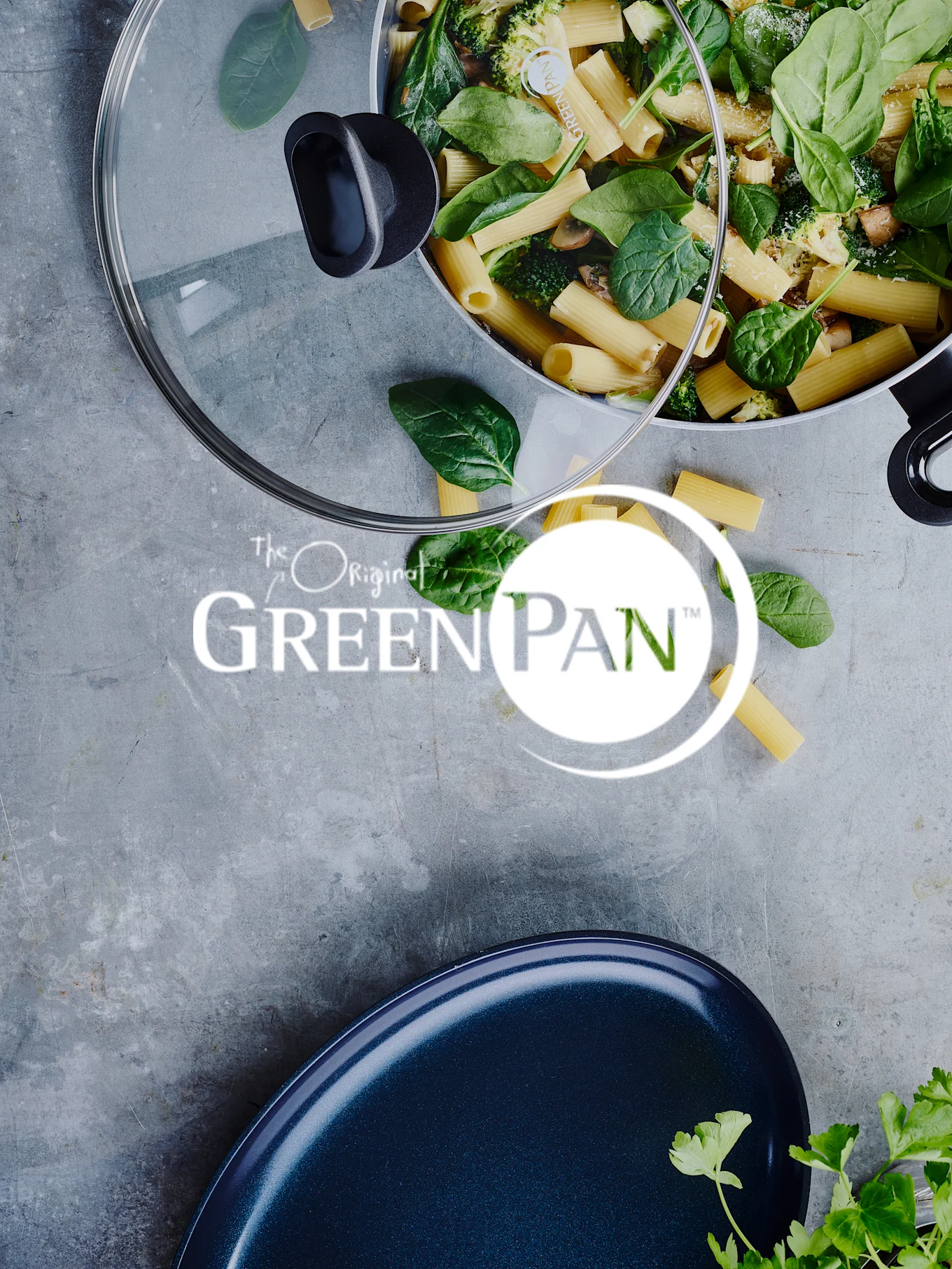 Pasta met spinazie en broccoli in een pan, met een glazen deksel en het 'GreenPan'-logo zichtbaar.