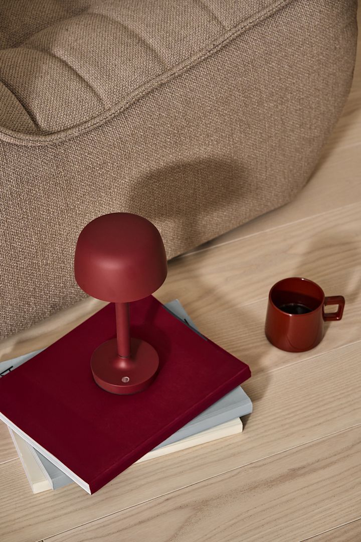 Een van de grootste trends van 2024 is chroom. Hier staat de favoriete lamp van velen, de VP9 draagbare tafellamp Flowerpot in chroom, op een krukje naast een glas champagne.